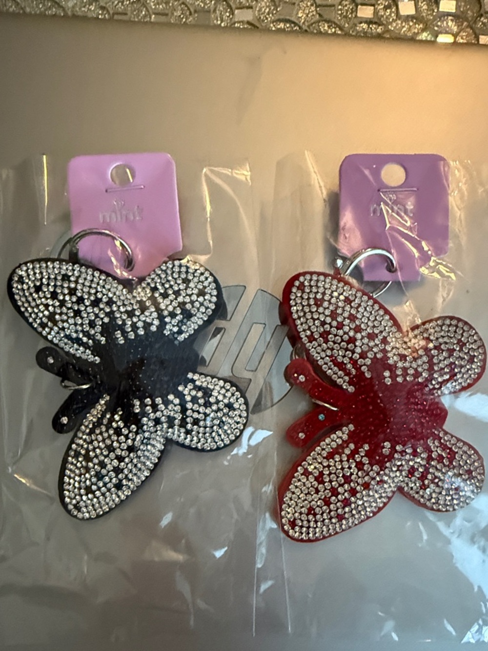 Set of 2 Sparkle Butterfly Keychains in Silver Tone. One red and one black.